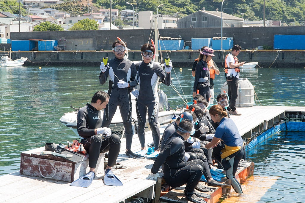 ドルフィンスイム体験は10人前後が１組になり、合計３回に分けて行われた。写真中央でTORQUE G02をこちらに向けているのが、今回ドルフィンスイムを体験するカメラマン稲田と、T&S編集担当の榎本