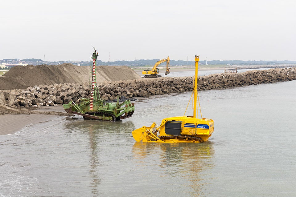 活躍の現場（左：水陸両用ブルドーザー、右：水中施工ロボット）