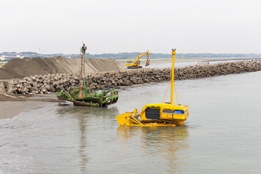 活躍の現場（左：水陸両用ブルドーザー、右：水中施工ロボット）